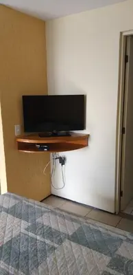 Uma televisão e/ou sistema de entretenimento em ApartHotel - Praia Mansa 1 e 2 Qtos