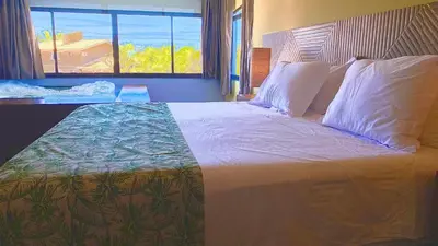 Uma cama ou camas num quarto em CHEZ TUPÃ SUÍTES
