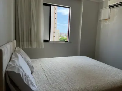 Uma cama ou camas num quarto em Espaçoso 2 rooms, ampla varanda perto do mar