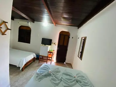 Uma cama ou camas num quarto em Pousada Tropicalia