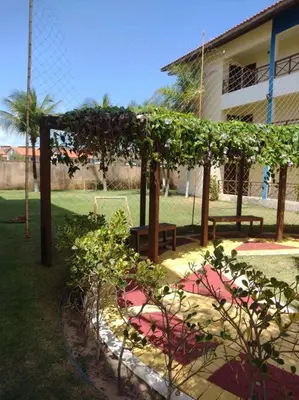 Um jardim no exterior de Lindo apartamento próximo ao Beach Park
