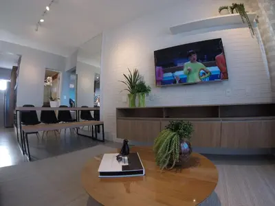 Uma televisão e/ou sistema de entretenimento em Lindo apartamento com vista mar 2 quartos 1501