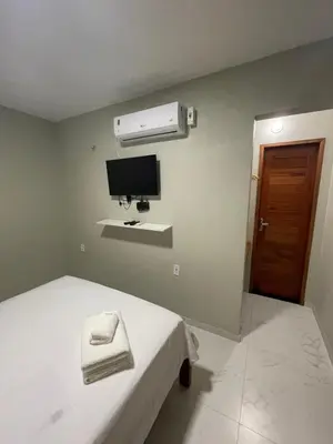 Uma televisão e/ou sistema de entretenimento em Suítes Paraíso Perfeito