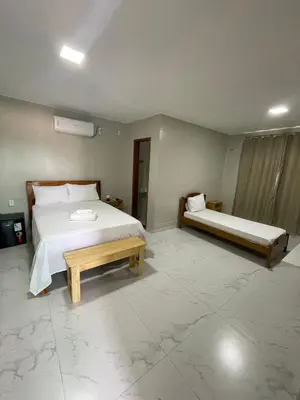 Uma cama ou camas num quarto em Suítes Paraíso Perfeito