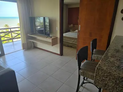 Uma televisão e/ou sistema de entretenimento em Beachfront Apartamento 424A Kariri Beach for 2 persons