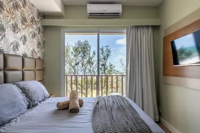 Uma cama ou camas num quarto em Raridade do Beach Park Living Pé na areia e vista mar