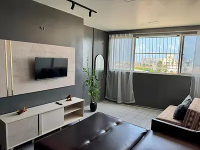 Uma televisão e/ou sistema de entretenimento em Vista mar, piscina, na praia do futuro, com Ar condicionado e Wi-Fi