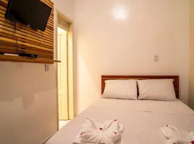 Uma cama ou camas num quarto em Suítes Pe na Areia