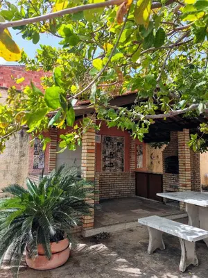 Um jardim no exterior de Casa com churrasqueira, varanda e uma brisa especial