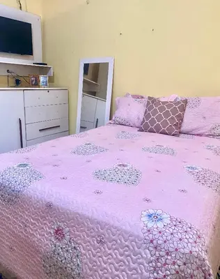 Uma cama ou camas num quarto em Casa da Helô
