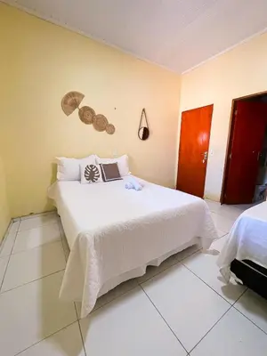 Uma cama ou camas num quarto em casa amarela trairi flecheiras