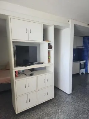 Uma televisão e/ou sistema de entretenimento em Flat vista para o mar