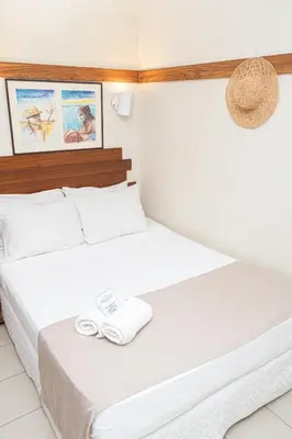 Uma cama ou camas num quarto em Portal Da Praia Hotel