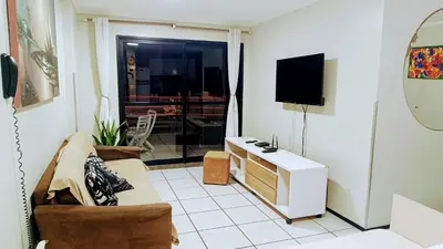 Uma televisão e/ou sistema de entretenimento em Excelente apto 2 quartos com vista para mar