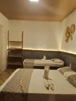 Uma cama ou camas num quarto em Mansão Rústica 10 Suítes a 150 metros do Mar e Beach Park