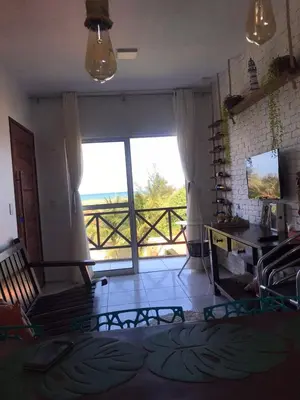 Uma televisão e/ou sistema de entretenimento em Apartamento com vista para o mar, piscina , deck , playground e estacionamento .
