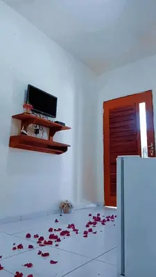 Uma televisão e/ou sistema de entretenimento em Suíte das flores em Guajiru
