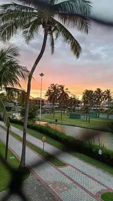 Um jardim no exterior de Apartamento Aquaville Pé na areia e Água coco