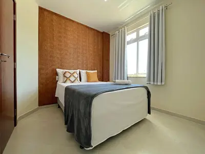 Uma cama ou camas num quarto em TOP 2 QUARTOS em Condominio- PISCINA, CHURRASQUEIRA, ESTACIONAMENTO, PARQUINHO INFANTIL, Wi-Fi e home office, Ar Condicionado, SmarTV e Cozinha Completa I 800m da praia e parque aquatico CE